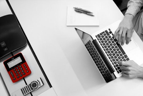 Person typing on laptop behind a desk