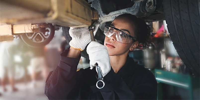 Mechanic working on underside of vehicle