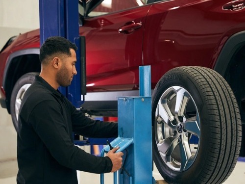 A Hyundai Trucks mechanic holding a ring spanner.