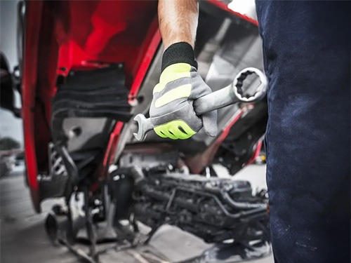 A Hyundai Trucks mechanic holding a ring spanner.