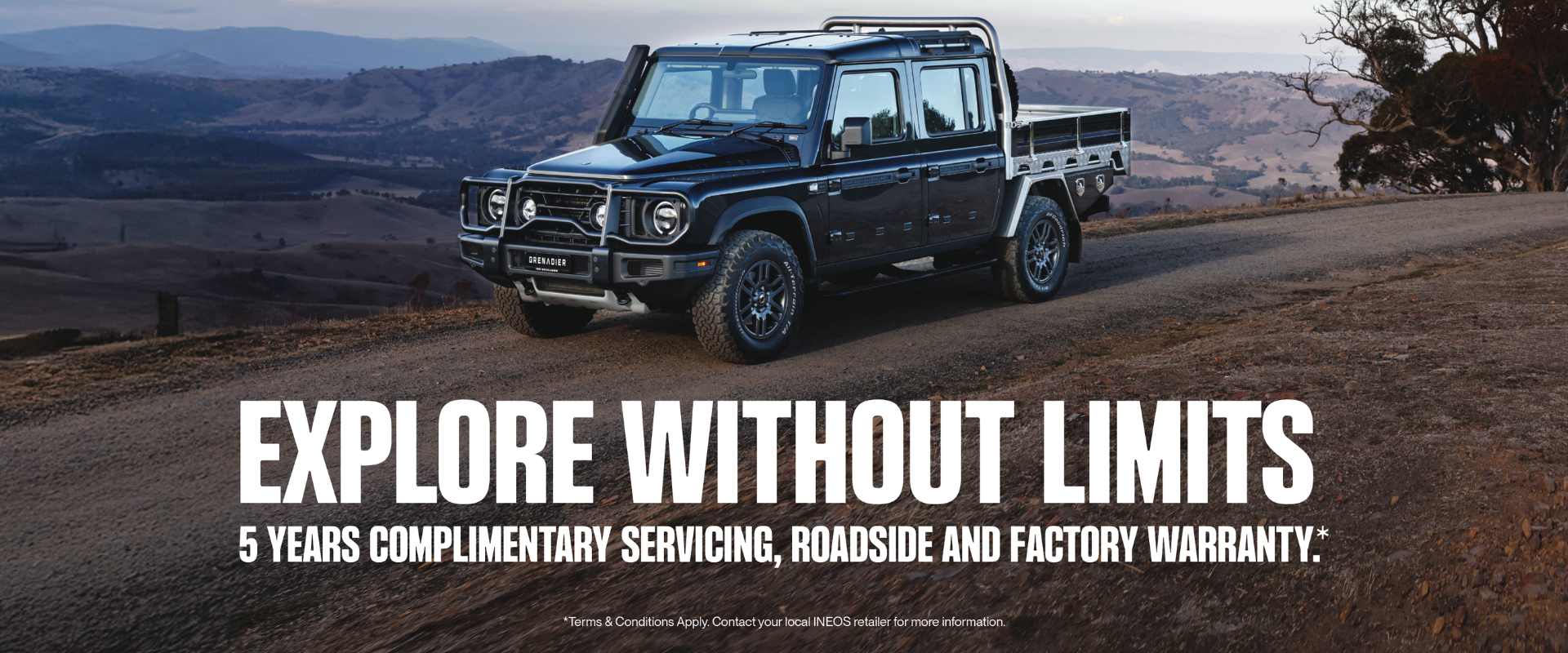 4x4 black car on the desert road, text reads explore without limits, subheading states 5 years complimentary servicing, roadside assistance, factory warranty.