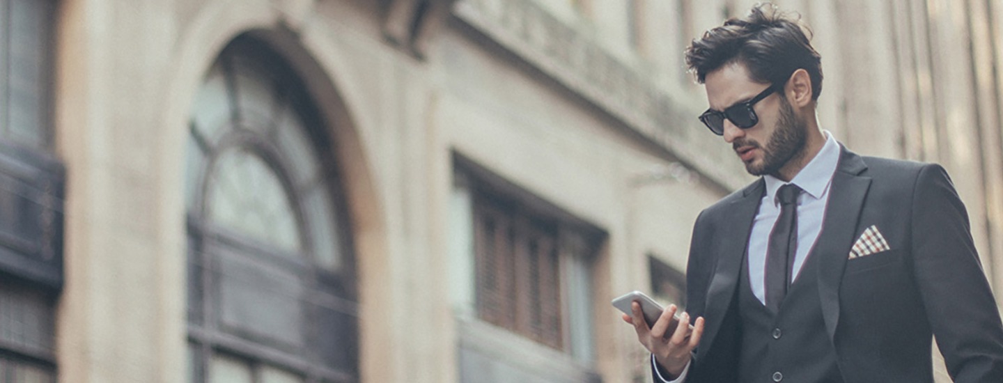 Man in suit looking at this phone