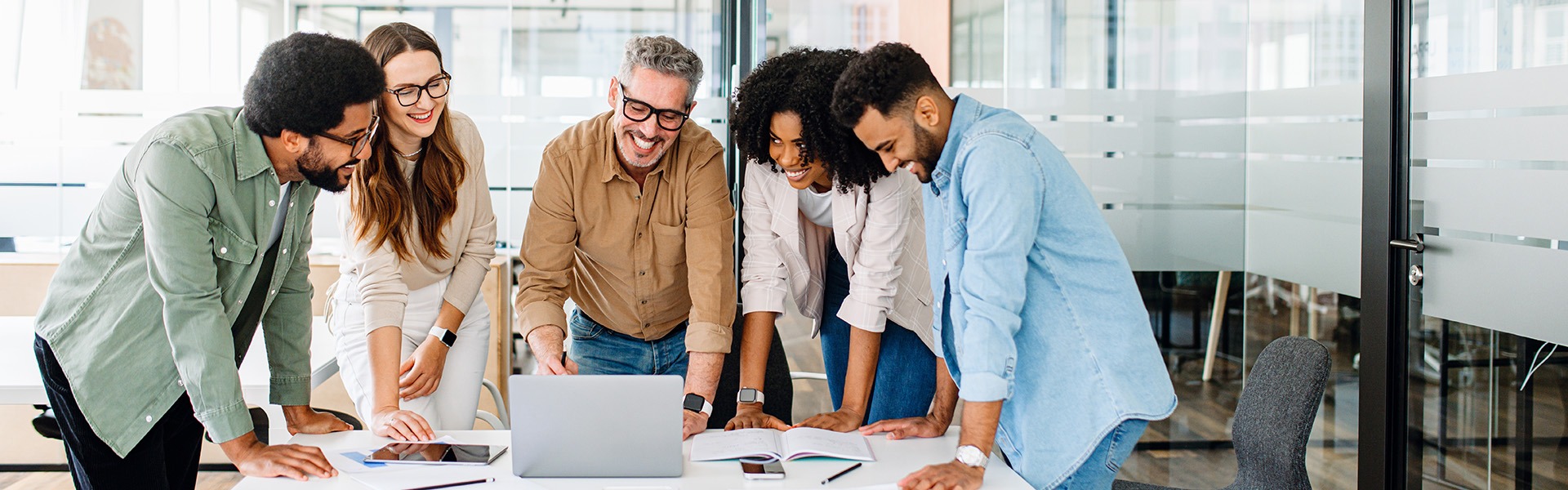People standing around a laptop
