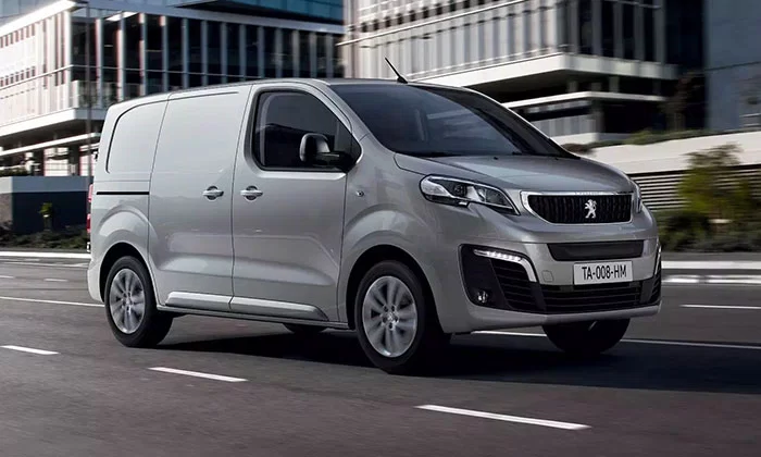 Peugeot Expert commercial van driving on a city road, side view, highlighting modern design and urban capability