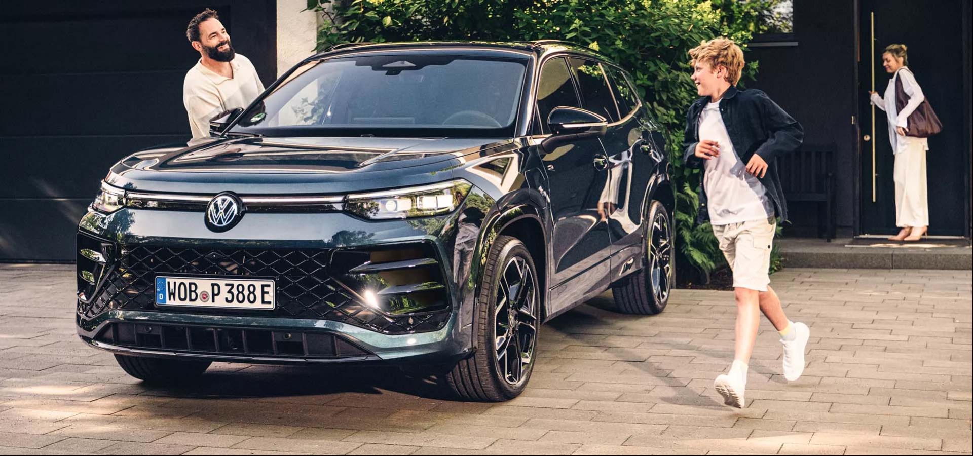 Tayron eHybrid parked in driveway with Family